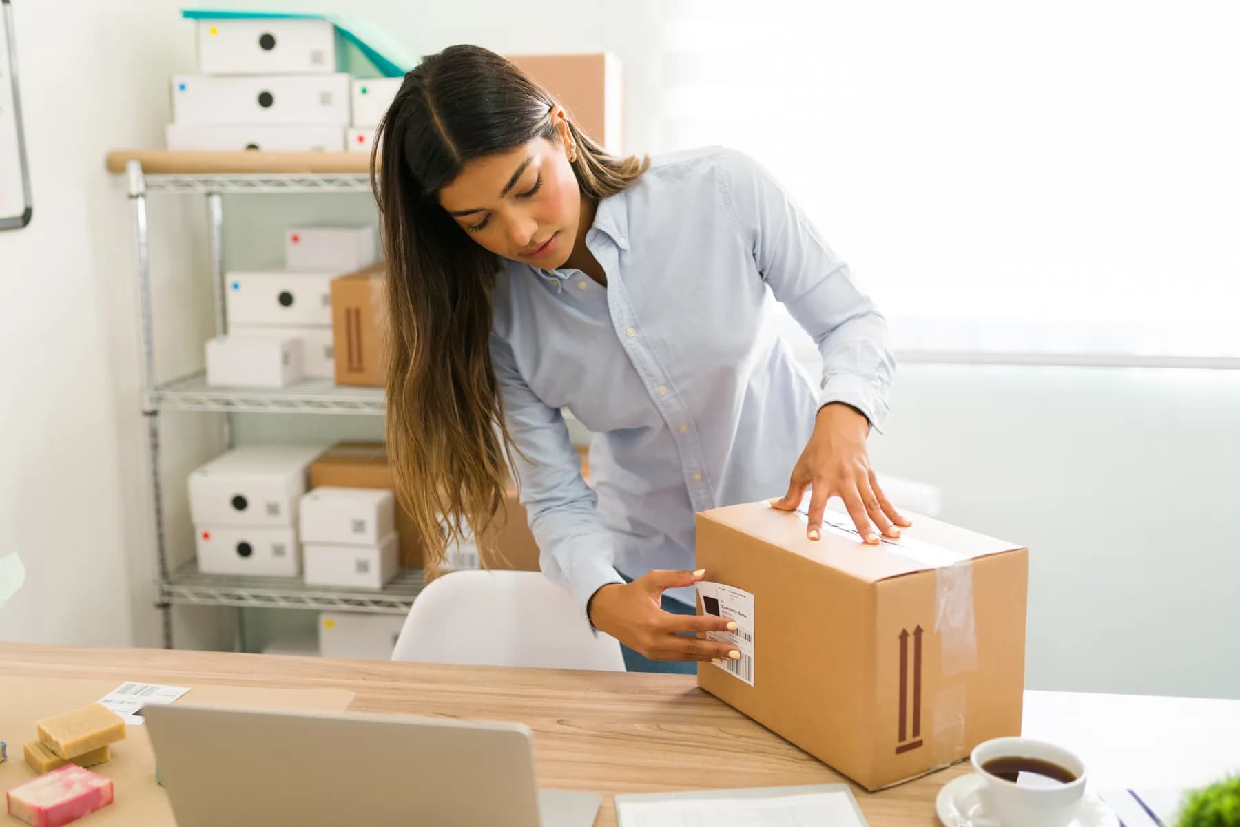 A founder labelling a package of her beauty products